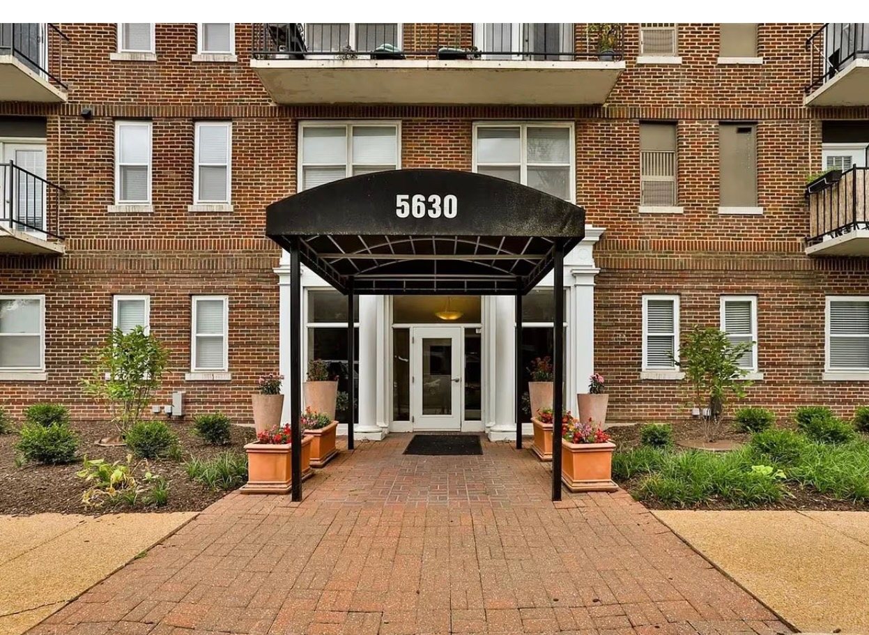 Front entrance of 5630 Pershing Ave with historic brick facade and black canopy