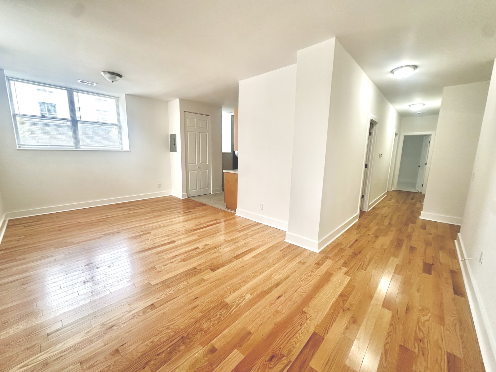 Living area with oak hardwood flooring and natural light